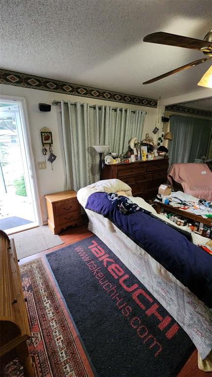 A living room features a sofa, a wooden dresser, and a branded floor mat — 14451 SE 45TH COURT, SUMMERFIELD, FL