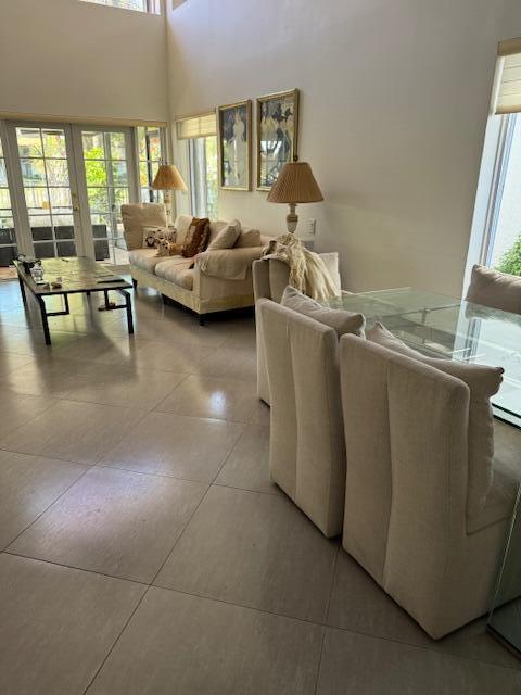 A bright living room features a white sofa, a coffee table, and a wall-mounted television — 5544 Fox Hollow Drive, Boca Raton FL 33486, BOCA RATON, FL