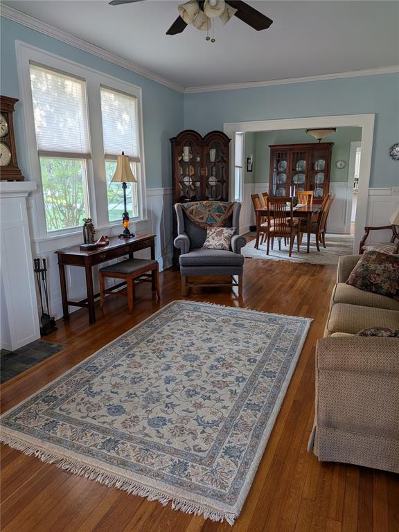 A living room with hardwood floors, a patterned area rug, and a view into the dining room — 410 E PARK STREET, LAKELAND, FL