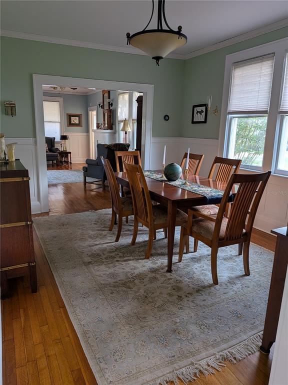 A dining room with a wooden table, chairs, area rug, and a view into another room — 410 E PARK STREET, LAKELAND, FL