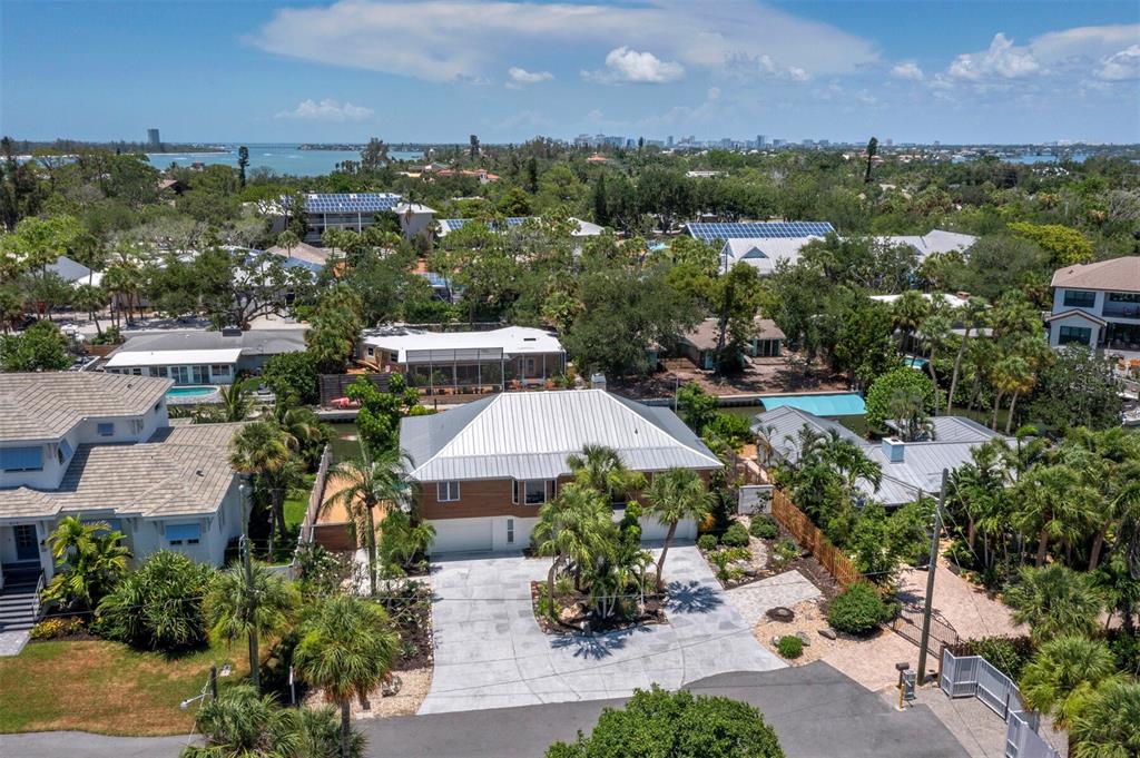 An aerial view shows a single-story house with a metal roof and a paved driveway — 521 CUMMINGS STREET, SARASOTA, FL