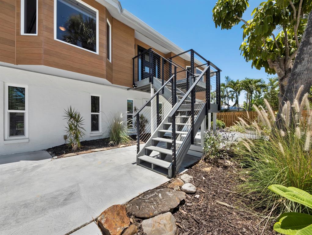 A modern exterior staircase with metal railings leads to the elevated deck of a house — 521 CUMMINGS STREET, SARASOTA, FL