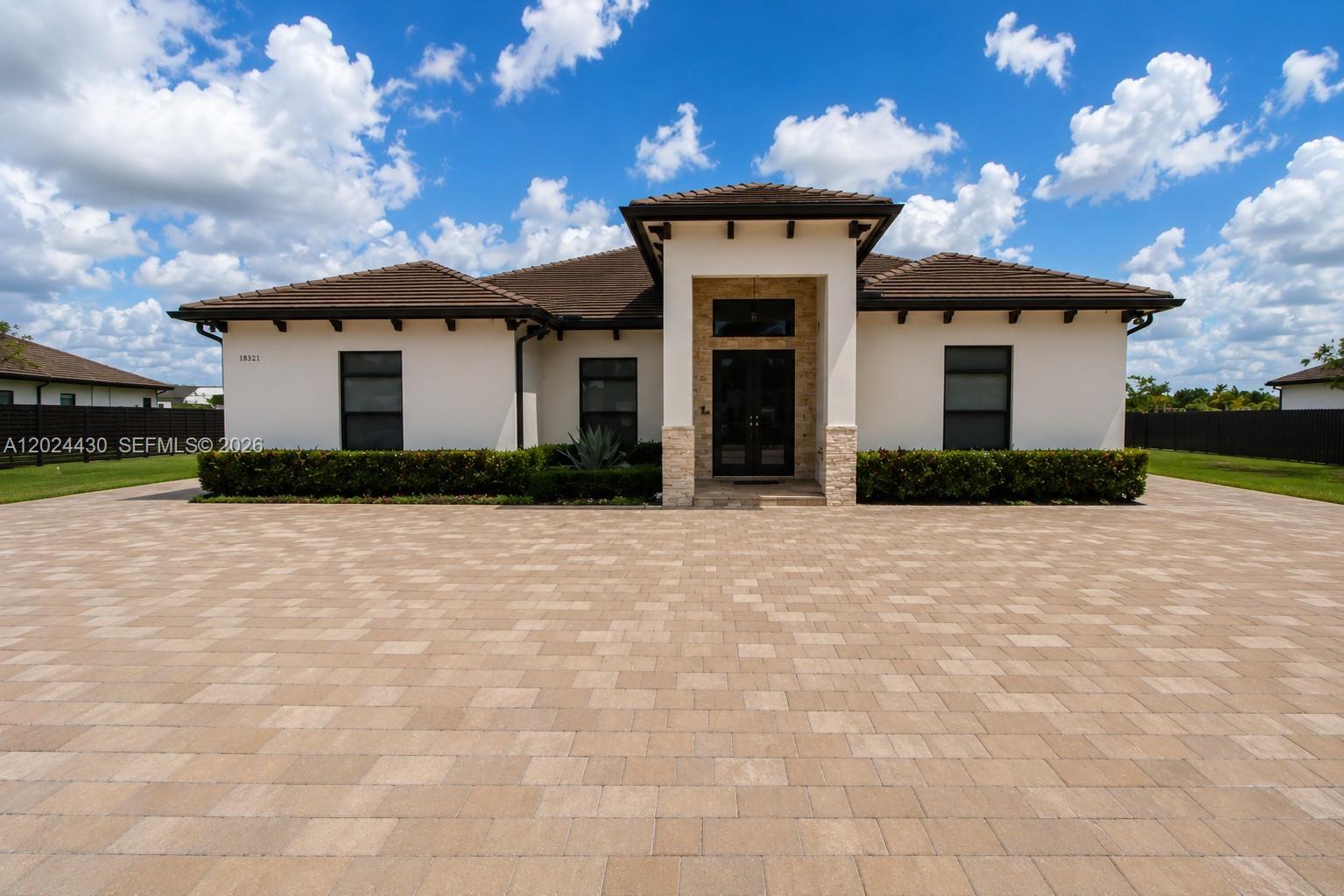 A single-story house with a paved driveway, white stucco walls, and a dark tile roof — 18321 SW 224th St # 0, Miami FL 33170, MIAMI, FL