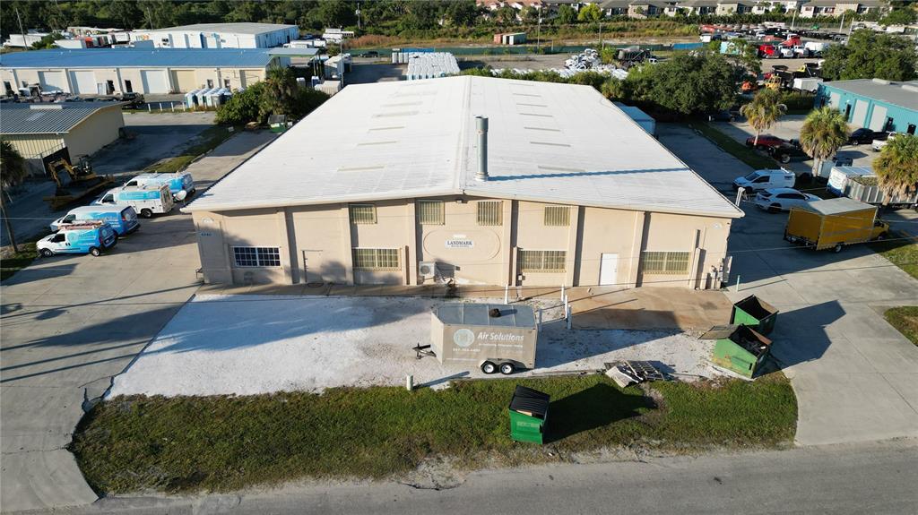 An aerial view shows a beige industrial warehouse building with a white metal roof — 4240 JAMES STREET UNIT 10,11,12,13,14, PUNTA GORDA, FL