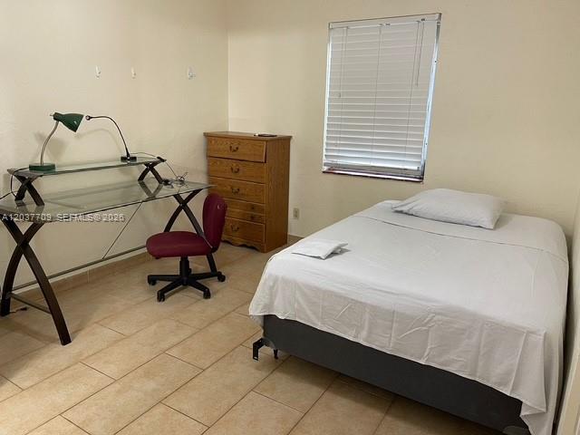A bedroom features a glass desk, a wooden dresser, and a bed with white linens — 6510 SW 58th Ave, South Miami FL 33143, SOUTH MIAMI, FL