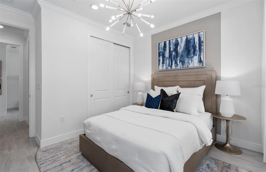 A bedroom features a bed with white bedding, a blue abstract painting, and a chandelier — 6807 SUNRISE COVE DRIVE, CLERMONT, FL