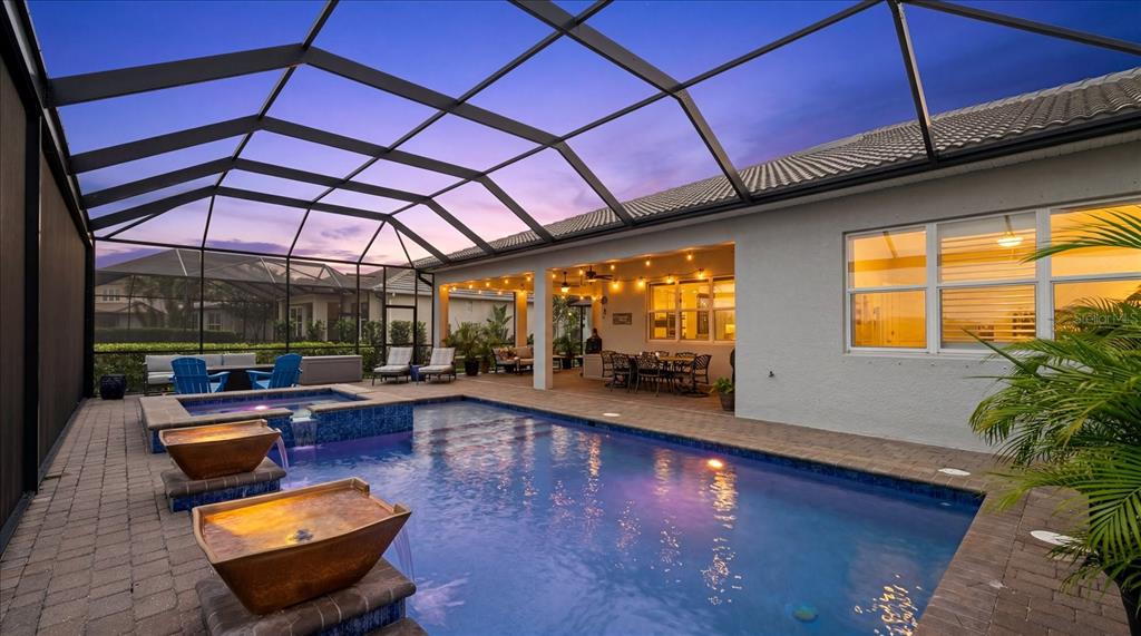 A screened-in patio features a swimming pool, a hot tub, and a covered dining area — 12105 SEABROOK AVENUE, BRADENTON, FL