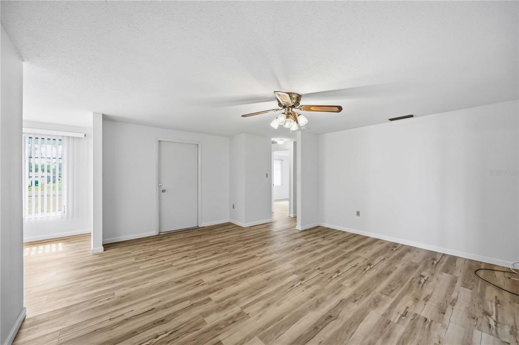 An empty room with white walls, a ceiling fan, and light wood-look flooring — 3249 SUNRISE TRAIL, PORT CHARLOTTE, FL