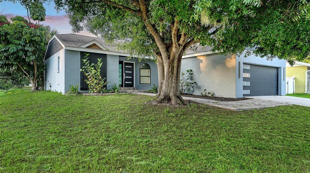 A single-story house with a gray exterior, a large front tree, and a two-car garage — 2481 S SCARLET OAK COURT, SARASOTA, FL