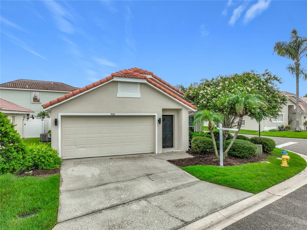 A single-story house with a beige exterior, a two-car garage, and a tiled roof — 998 WHITE SPRINGS LANE, WINTER SPRINGS, FL