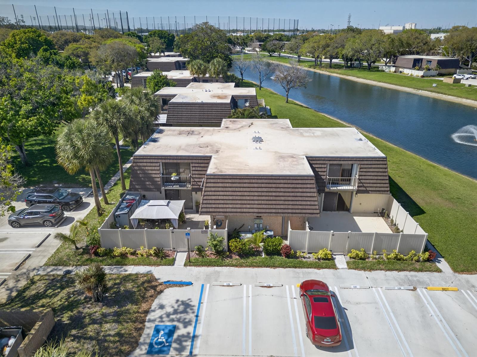 An aerial view shows a multi-unit residential building with brown roofs next to a canal — 7811 78th Way, West Palm Beach FL 33407, WEST PALM BEACH, FL