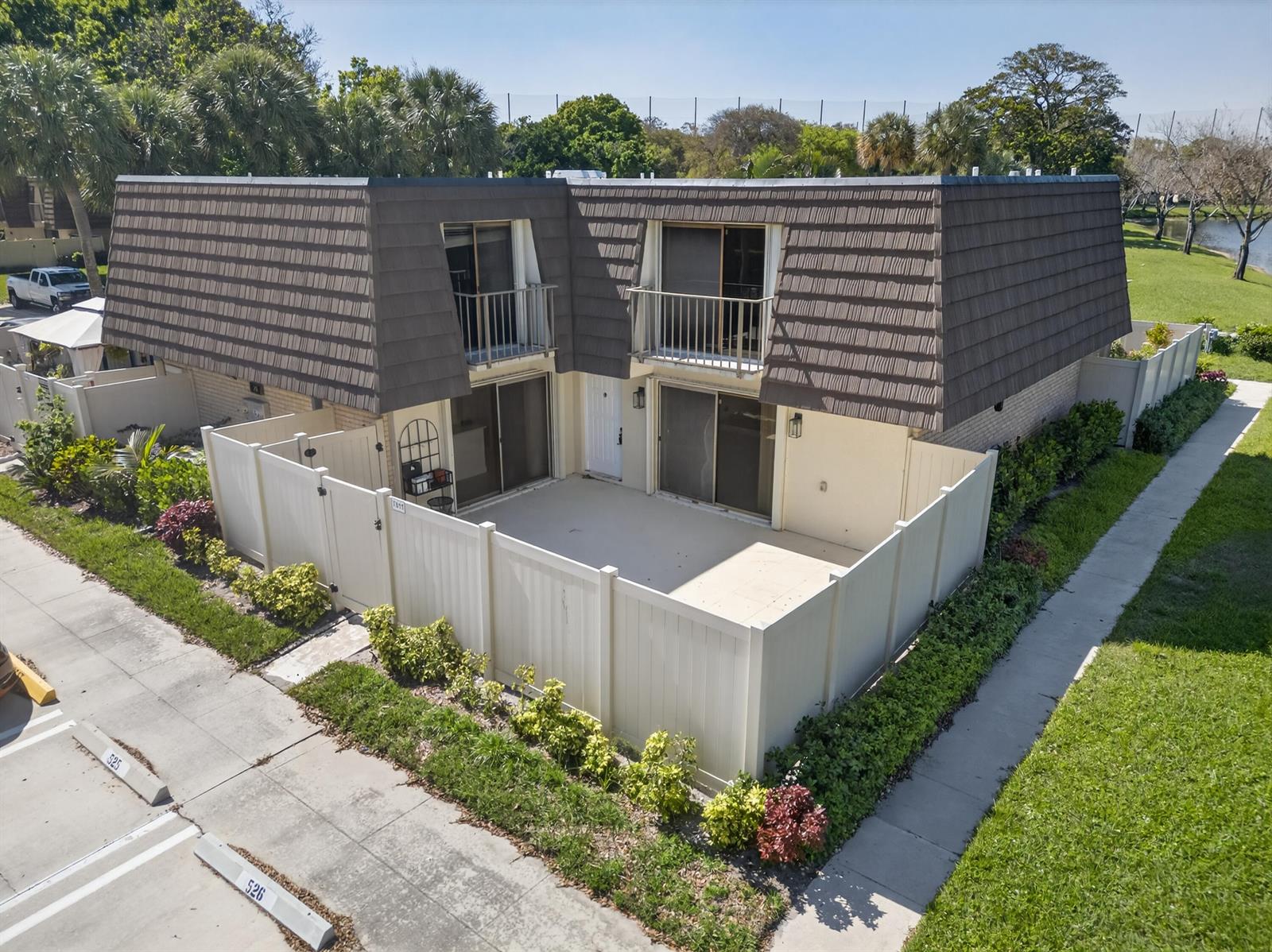 An aerial view of a two-story townhouse with a fenced patio and brown mansard roof — 7811 78th Way, West Palm Beach FL 33407, WEST PALM BEACH, FL