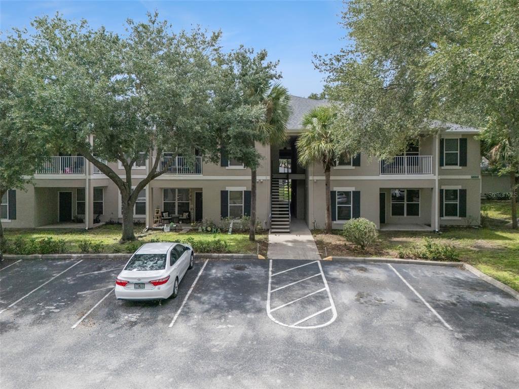 An exterior view of a two-story apartment building with a parking lot in front — 6005 HEMINGWAY CIRCLE, HAINES CITY, FL