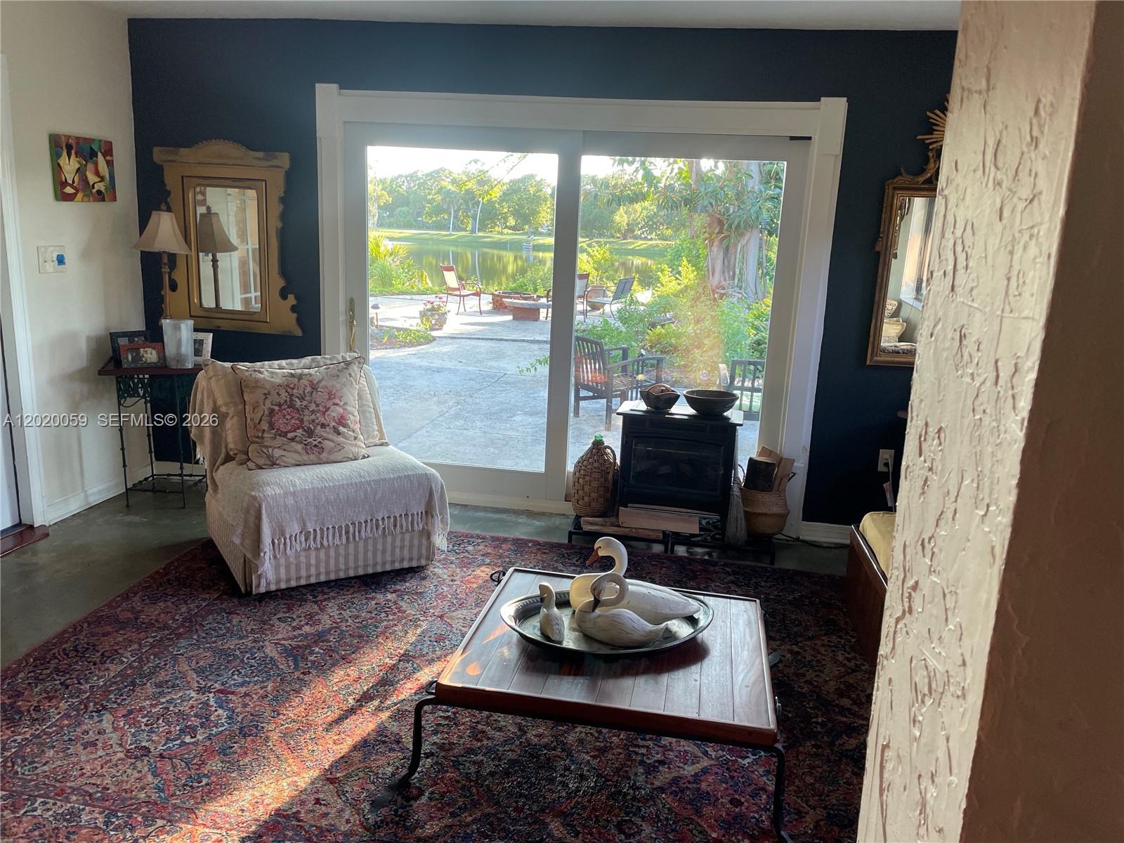 A living room features a dark accent wall, a patterned rug, and sliding glass doors — 6703 Oneco Way, Fort Pierce FL 34951, FORT PIERCE, FL