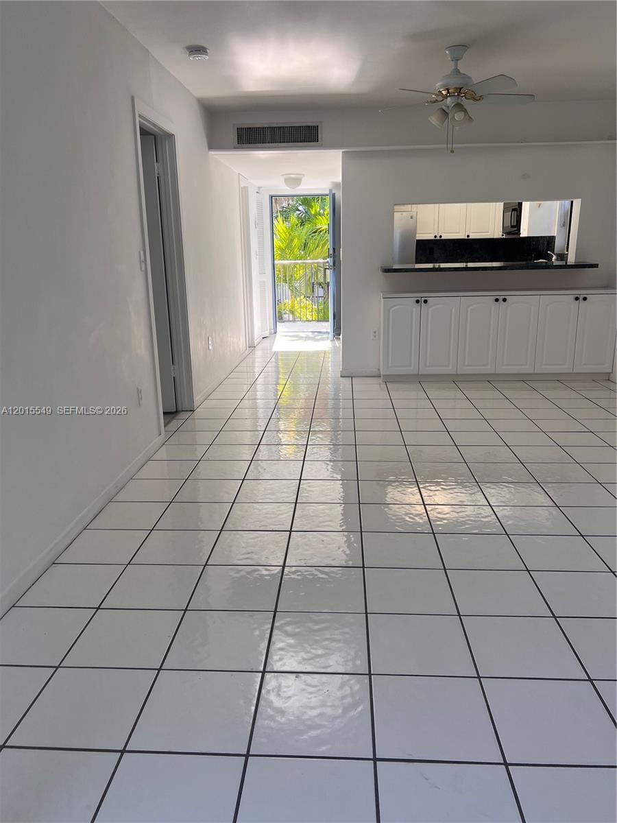 A white-tiled living area features a kitchen pass-through window and a door leading outside — 55 Ocean Lane Dr # 3030, Key Biscayne FL 33149, KEY BISCAYNE, FL