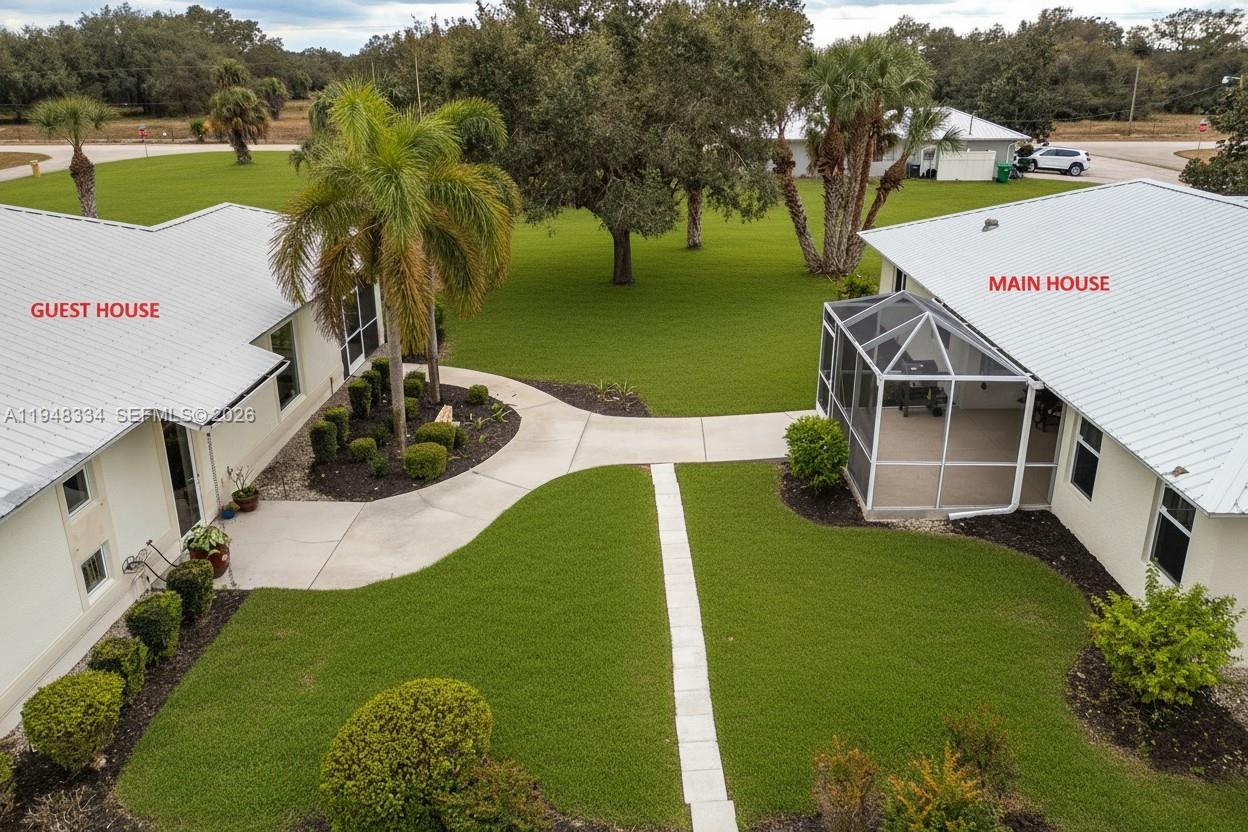 An aerial view shows a main house and guest house connected by a concrete walkway — 1197 April Ave, La Belle FL 33935, LA BELLE, FL
