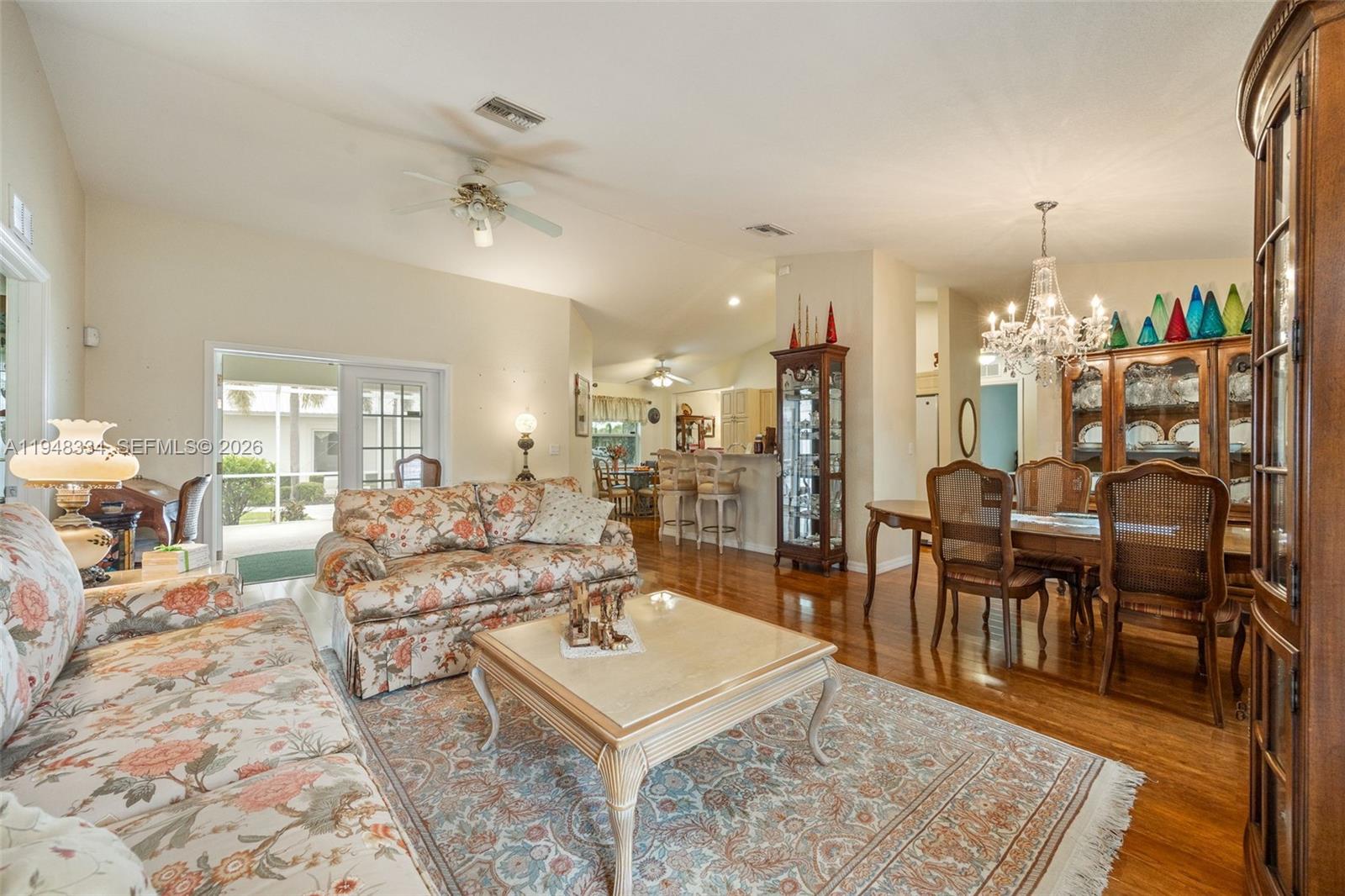 A dining room features a wooden table, chairs, two china cabinets, and a crystal chandelier — 1197 April Ave, La Belle FL 33935, LA BELLE, FL