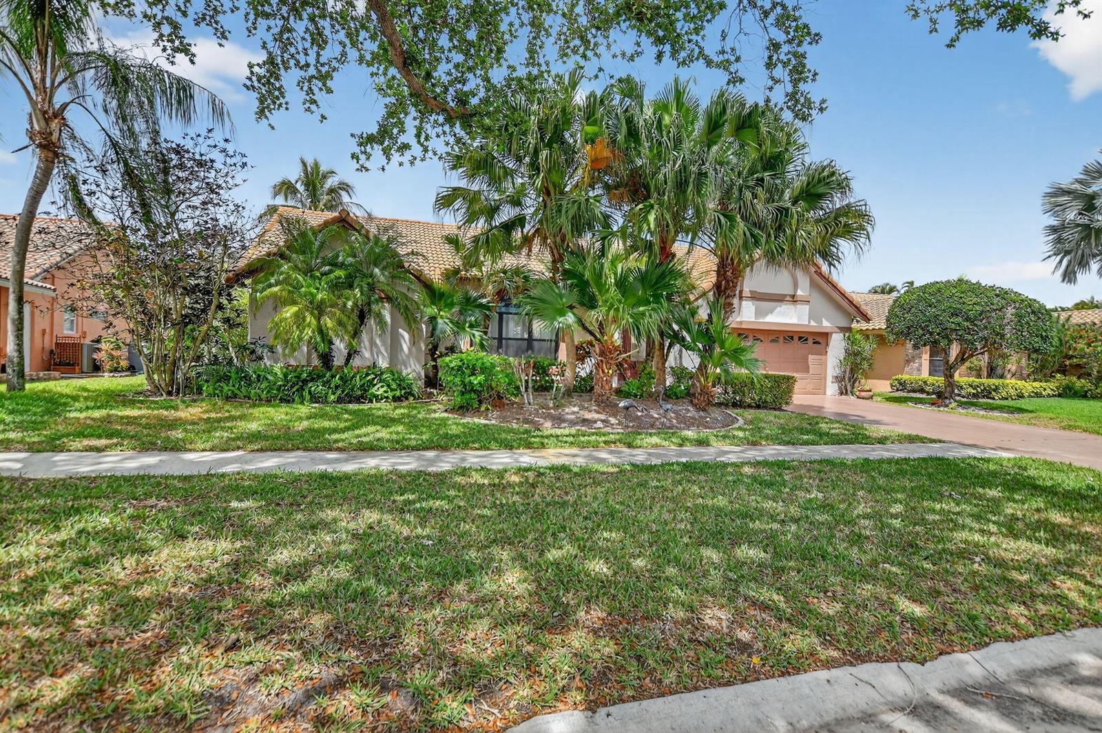 A single-story house with a tile roof, palm trees, and a driveway in front — 20174 Back Nine Drive, Boca Raton FL 33498, BOCA RATON, FL