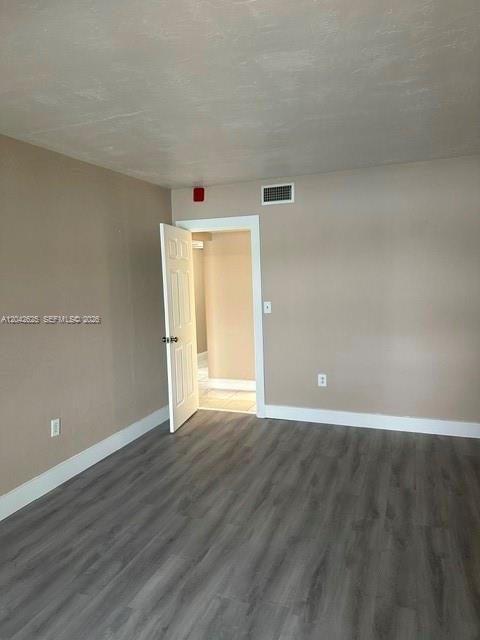An empty room features light gray walls, wood-look flooring, and an open doorway — 251 NE 187th St # 809, Miami FL 33179, MIAMI, FL