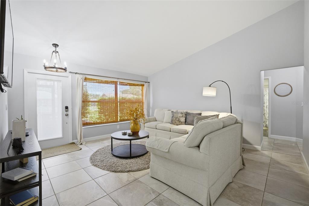 A living room features light tile floors, a neutral sectional sofa, and a large window — 6856 FAIRVIEW STREET, FORT MYERS, FL