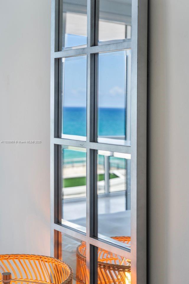 A grid-framed mirror reflects a view of the ocean and a balcony — 6799 Collins Ave # 804, Miami Beach FL 33141, MIAMI BEACH, FL