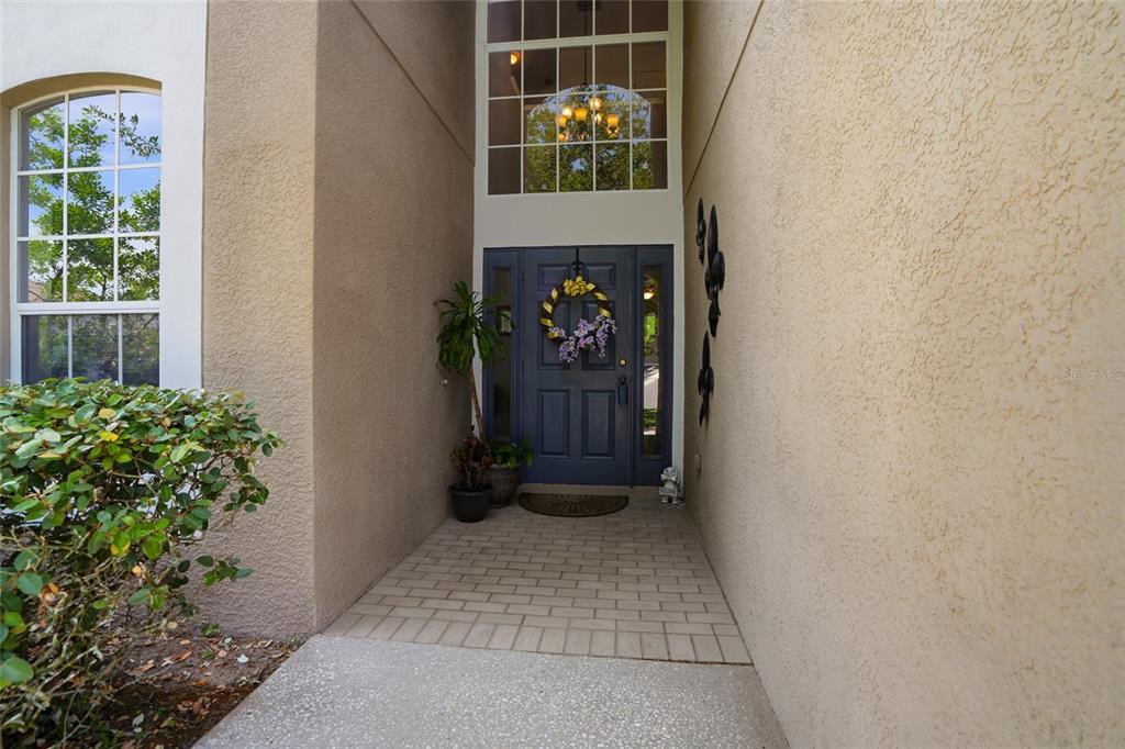 A front entryway features a blue door with sidelights, a wreath, and a tall window — 9643 ASBEL ESTATES STREET, LAND O LAKES, FL