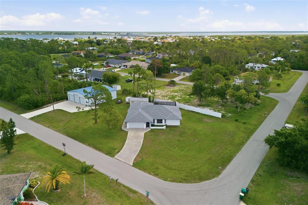 An aerial view shows a house with a detached garage on a large grassy lot — 5412 ULYSSES STREET, PORT CHARLOTTE, FL