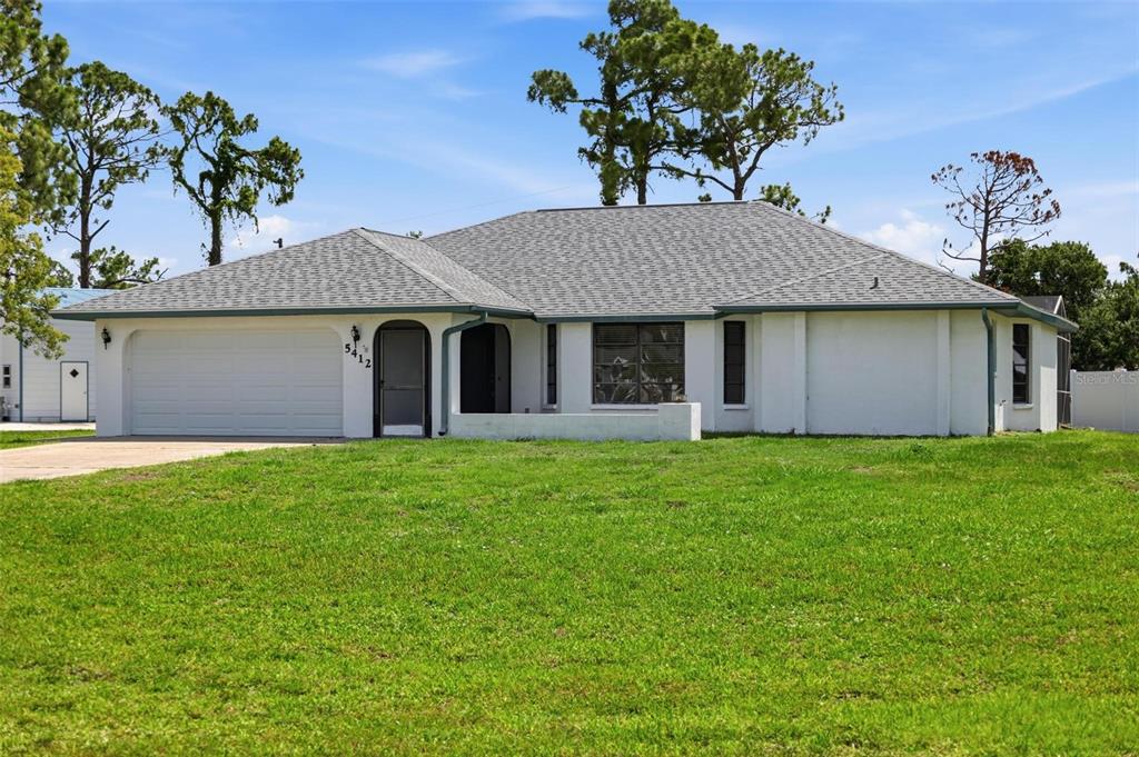 A single-story white house with a gray shingled roof and an attached two-car garage — 5412 ULYSSES STREET, PORT CHARLOTTE, FL