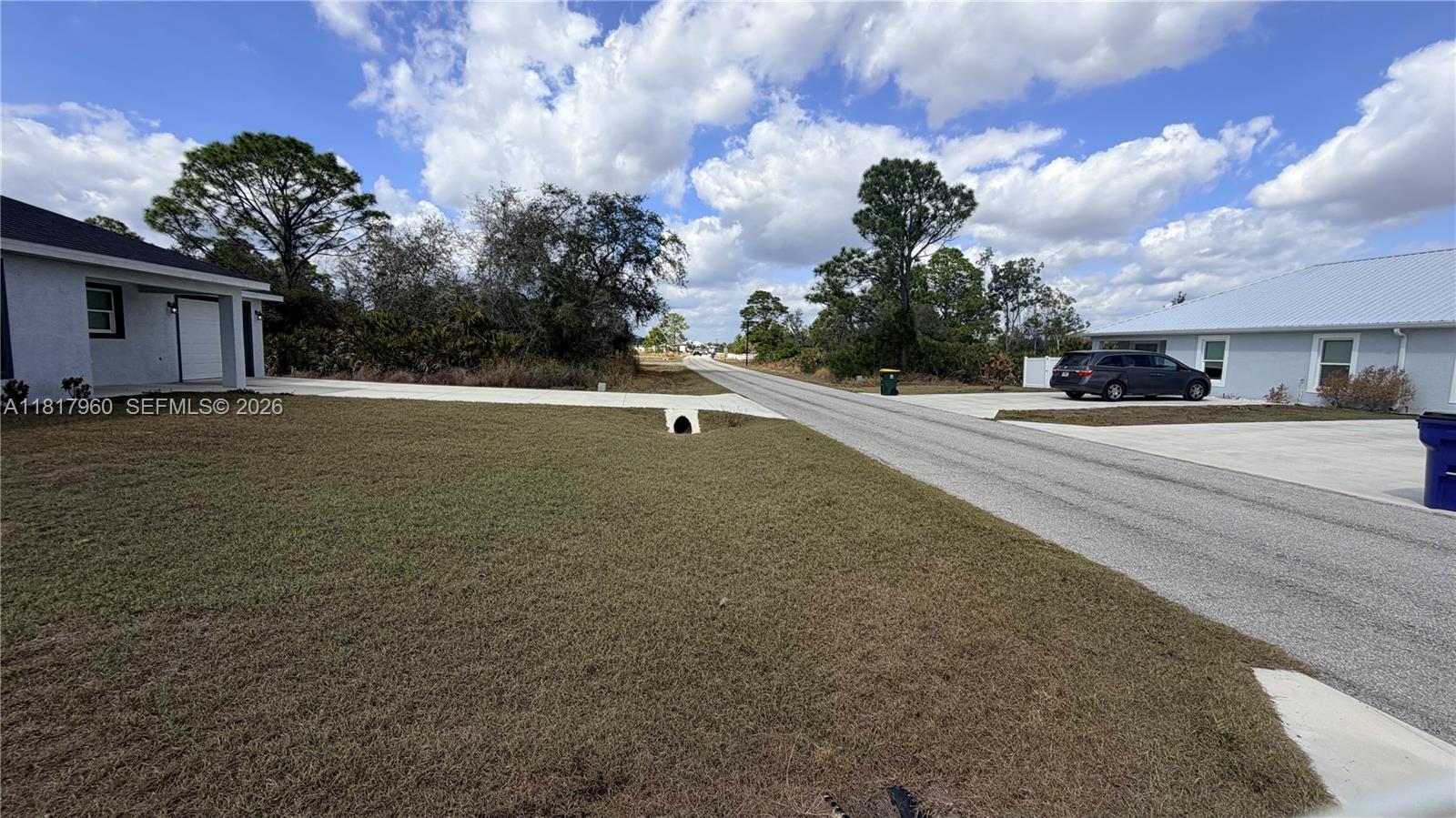 A paved road runs between two houses with lawns and a culvert in the foreground — 7006 San Bruno Dr, Sebring FL 33872, SEBRING, FL