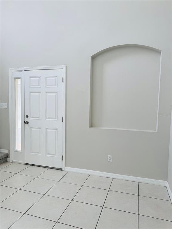 An entryway features a white front door with a sidelight, tile flooring, and an arched niche — 3517 TRAPNELL RIDGE DRIVE, PLANT CITY, FL