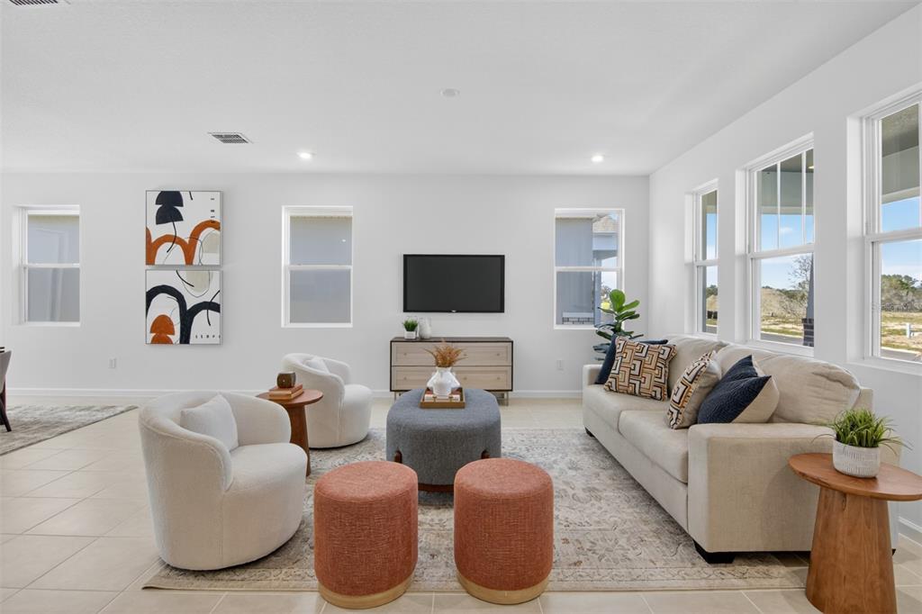 A kitchen features white cabinetry, granite countertops, a large island, and blue bar stools — 13685 SEAGRASS AVENUE, ORLANDO, FL