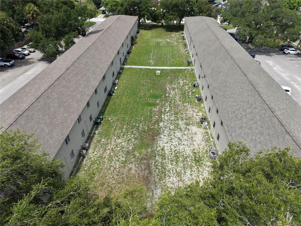 An aerial view shows two parallel apartment buildings separated by a grassy courtyard — 6450 78TH AVENUE N UNIT 38, PINELLAS PARK, FL