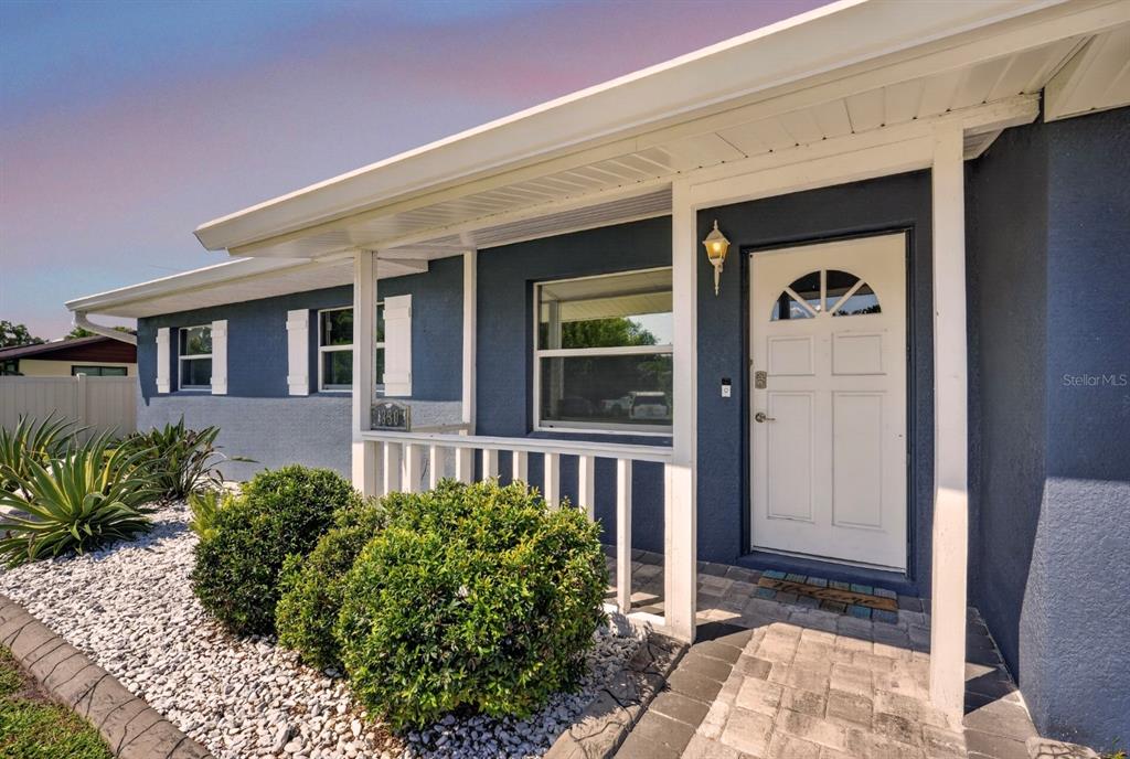 A blue house exterior features a white front door, a porch, and white landscaping rocks — 1330 S SHORE DRIVE, ST CLOUD, FL