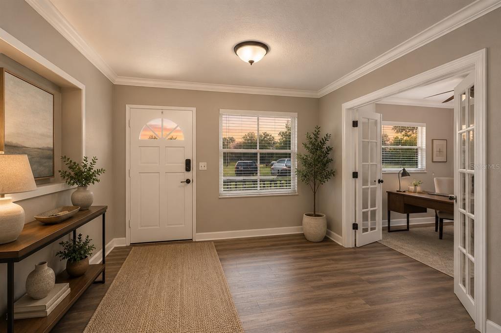 An entryway features wood-look flooring, a white front door, and French doors leading to an office — 1330 S SHORE DRIVE, ST CLOUD, FL