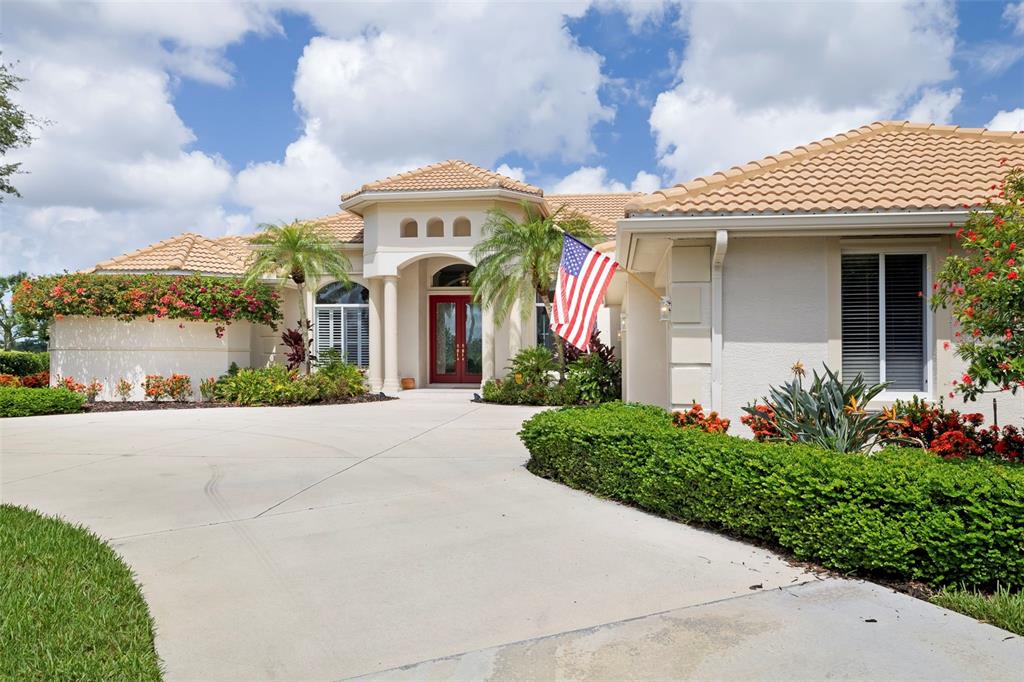 A single-story house with a tile roof, red front door, and a circular concrete driveway — 2528 TOM MORRIS DRIVE, SARASOTA, FL
