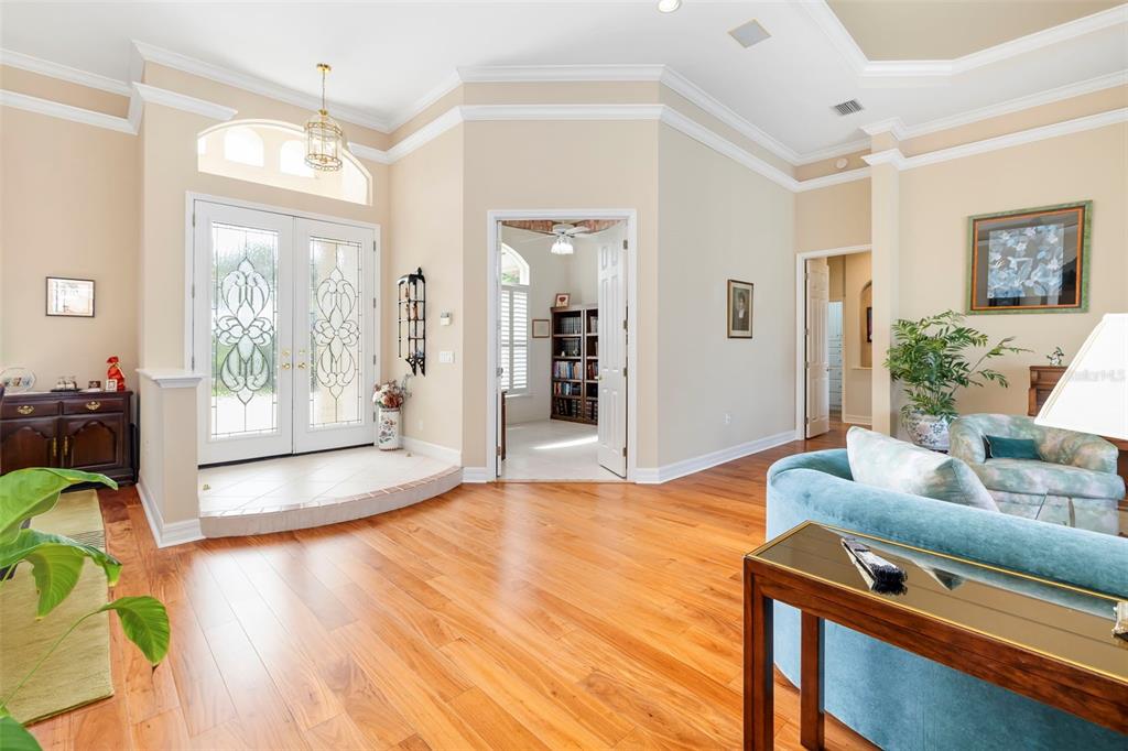 A bright entryway with a raised tiled landing, double glass doors, and hardwood flooring — 2528 TOM MORRIS DRIVE, SARASOTA, FL