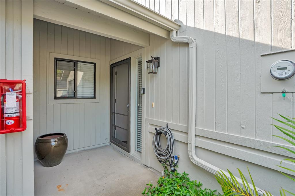 A covered entryway features a front door, a window, a fire extinguisher, and a hose reel — 4338 SEA MIST DRIVE, NEW SMYRNA BEACH, FL