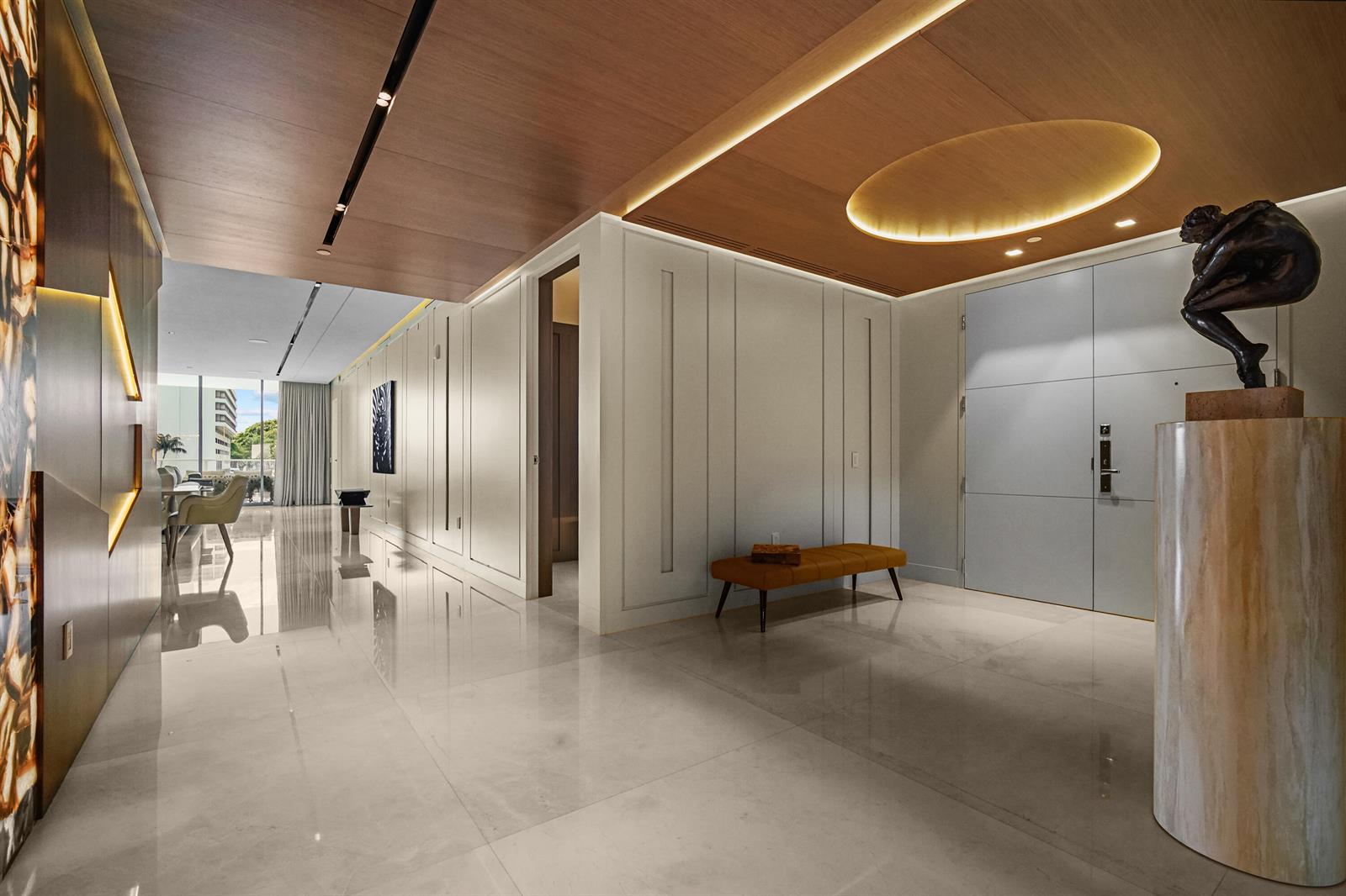 A modern entryway features a marble floor, a wooden ceiling, and a bronze sculpture pedestal — 725 S Ocean Boulevard # 206, Boca Raton FL 33432, BOCA RATON, FL