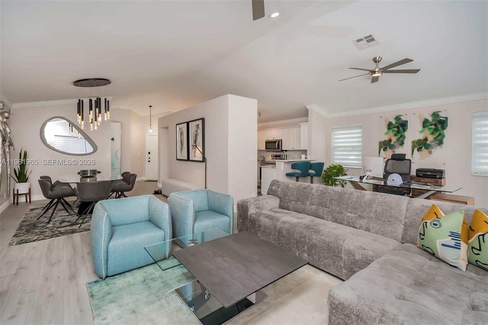 An open-concept living area features a gray sectional, blue armchairs, and a dining space — 11030 Harbour Springs Cir, Boca Raton FL 33428, BOCA RATON, FL