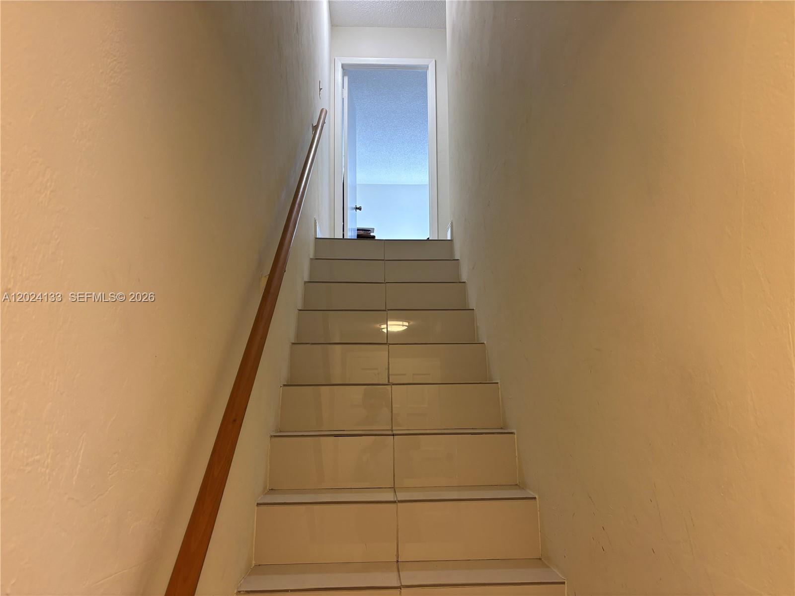A staircase with light-colored tile steps leads upward toward an open doorway — 10806 N Kendall Dr # 26, Miami FL 33176, MIAMI, FL