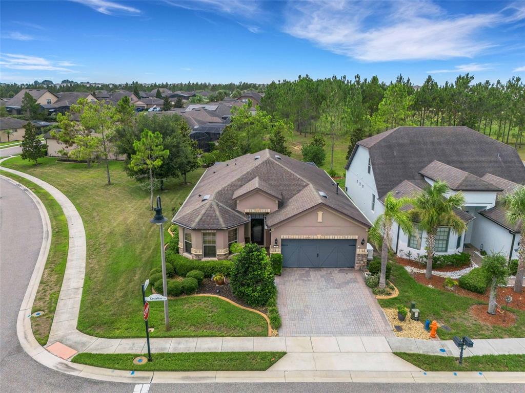An aerial view of a single-story suburban house with a gray garage and paved driveway — 100 CASTELLON COURT, DAVENPORT, FL