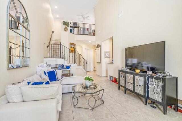 A living room features a white sectional sofa, a glass coffee table, and a television console — VERO BEACH, FL