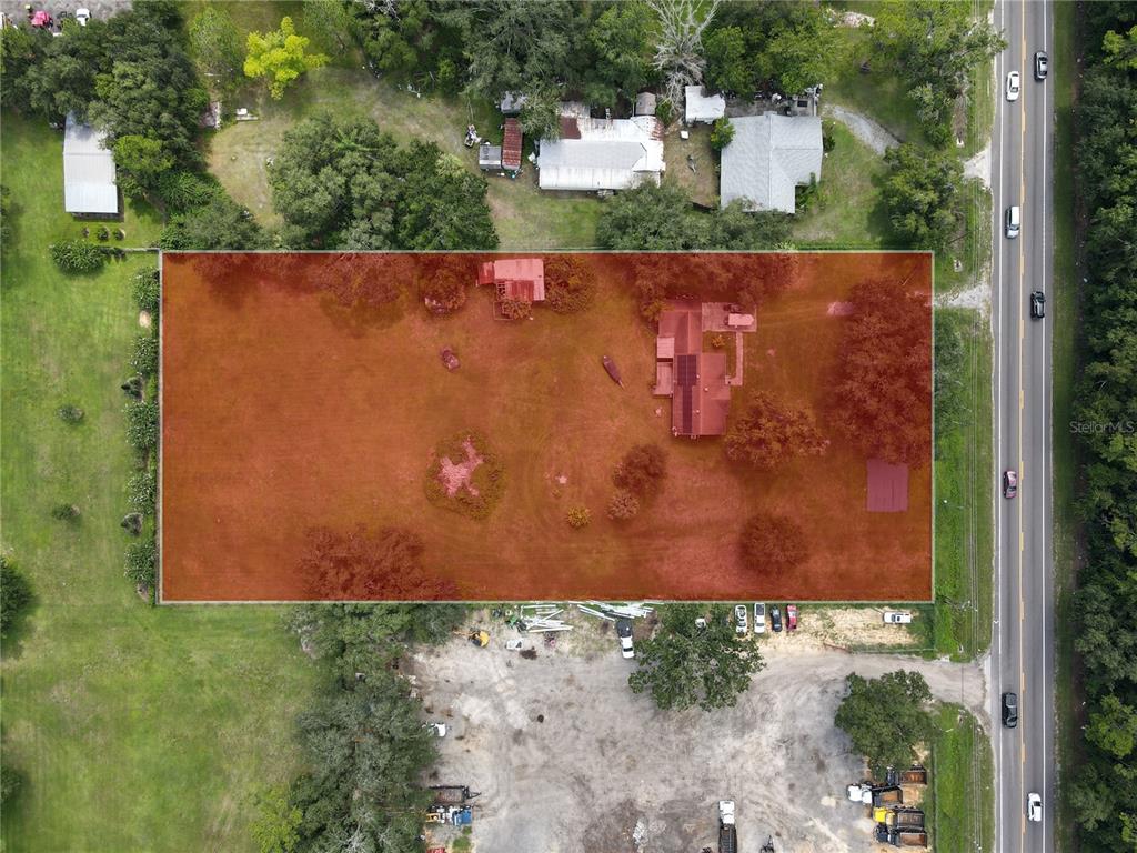 An aerial view shows a rectangular lot with a house and outbuildings highlighted in red — 6043 S ORANGE BLOSSOM TRAIL, DAVENPORT, FL