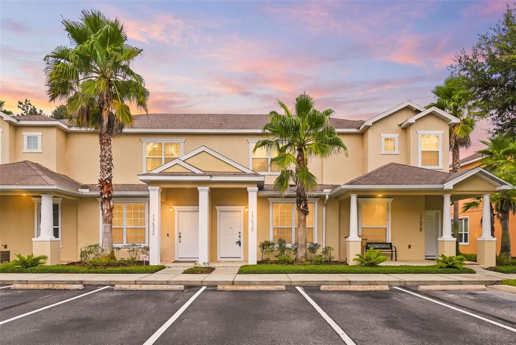 A multi-unit residential building with beige stucco walls, palm trees, and a parking lot — 17530 PLACIDITY AVENUE, CLERMONT, FL