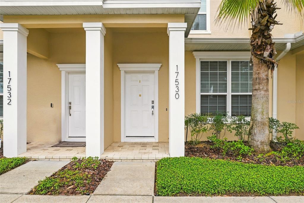 The exterior view shows two white front doors with house numbers on adjacent support columns — 17530 PLACIDITY AVENUE, CLERMONT, FL