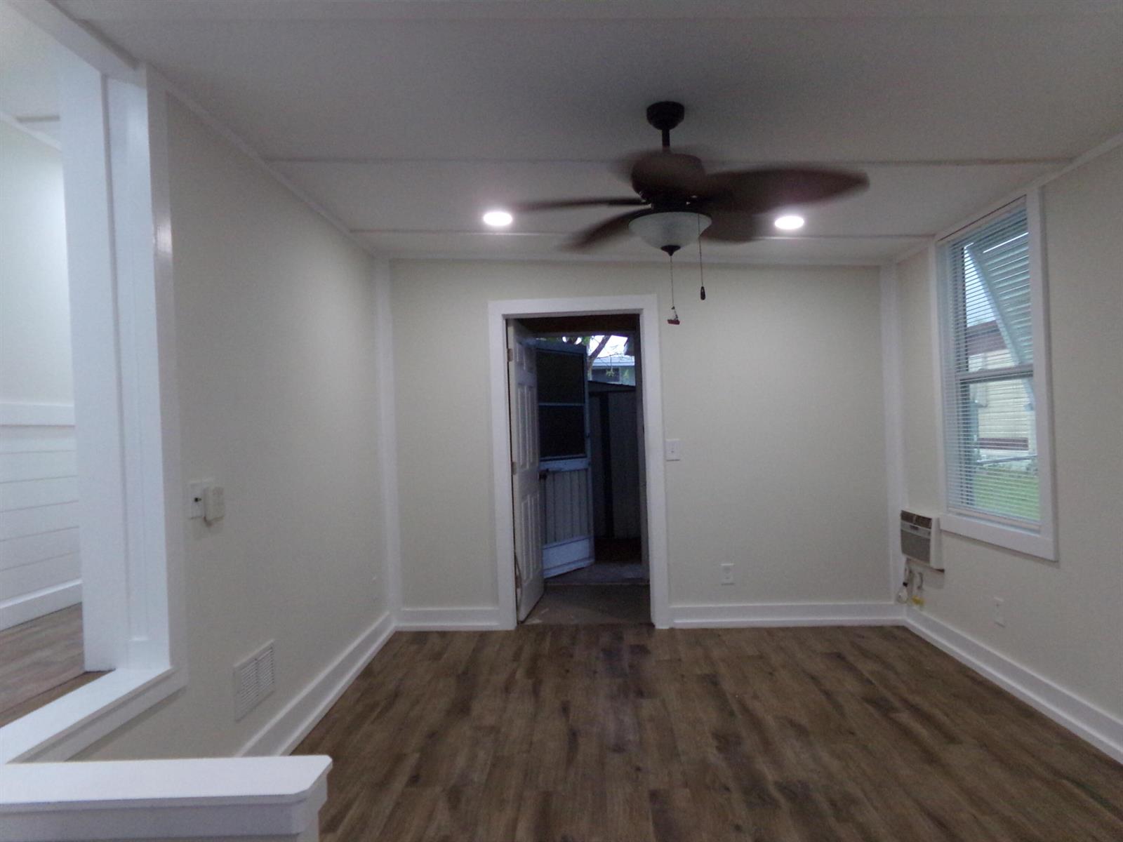 An empty room features light-colored walls, wood-look flooring, a ceiling fan, and an exterior door — 59005 Captiva Bay, Boynton Beach FL 33436, BOYNTON BEACH, FL