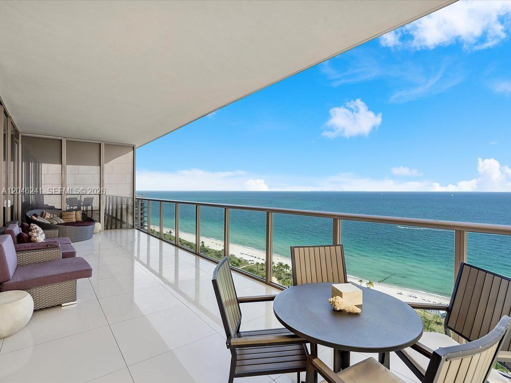 A spacious balcony features white tile flooring, outdoor seating, and a panoramic ocean view — 9705 Collins Ave # 1804N, Bal Harbour FL 33154, BAL HARBOUR, FL