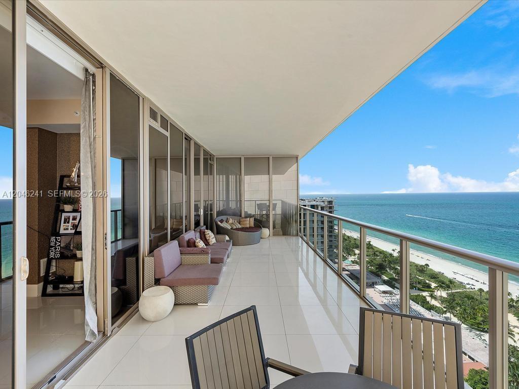 A spacious balcony with white tile flooring overlooks the ocean and a sandy beach — 9705 Collins Ave # 1804N, Bal Harbour FL 33154, BAL HARBOUR, FL