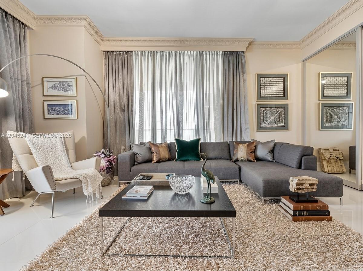 A living room features a grey sectional sofa, a coffee table, and a white armchair — 9705 Collins Ave # 1804N, Bal Harbour FL 33154, BAL HARBOUR, FL