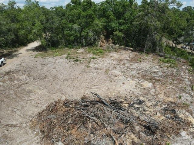An elevated view of a cleared, sandy residential lot surrounded by dense trees — X SE 143RD LN, UMATILLA, FL